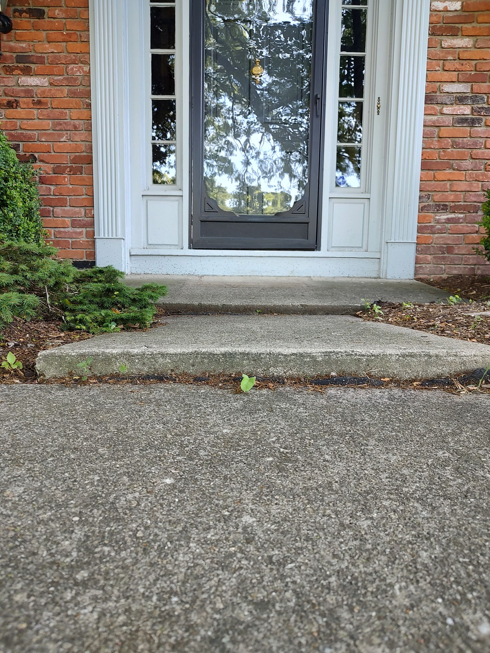 Irwin Concrete Leveling - Before Concrete Leveling the front porch has too much slope and the sidewalk at porch has a negative slope. There were two trip hazards.