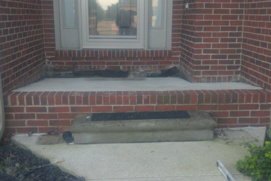 Irwin Concrete Leveling - Before Concrete Leveling there is a very severe front porch that is tilting back towards the house funneling water towards the foundation and causing a huge step