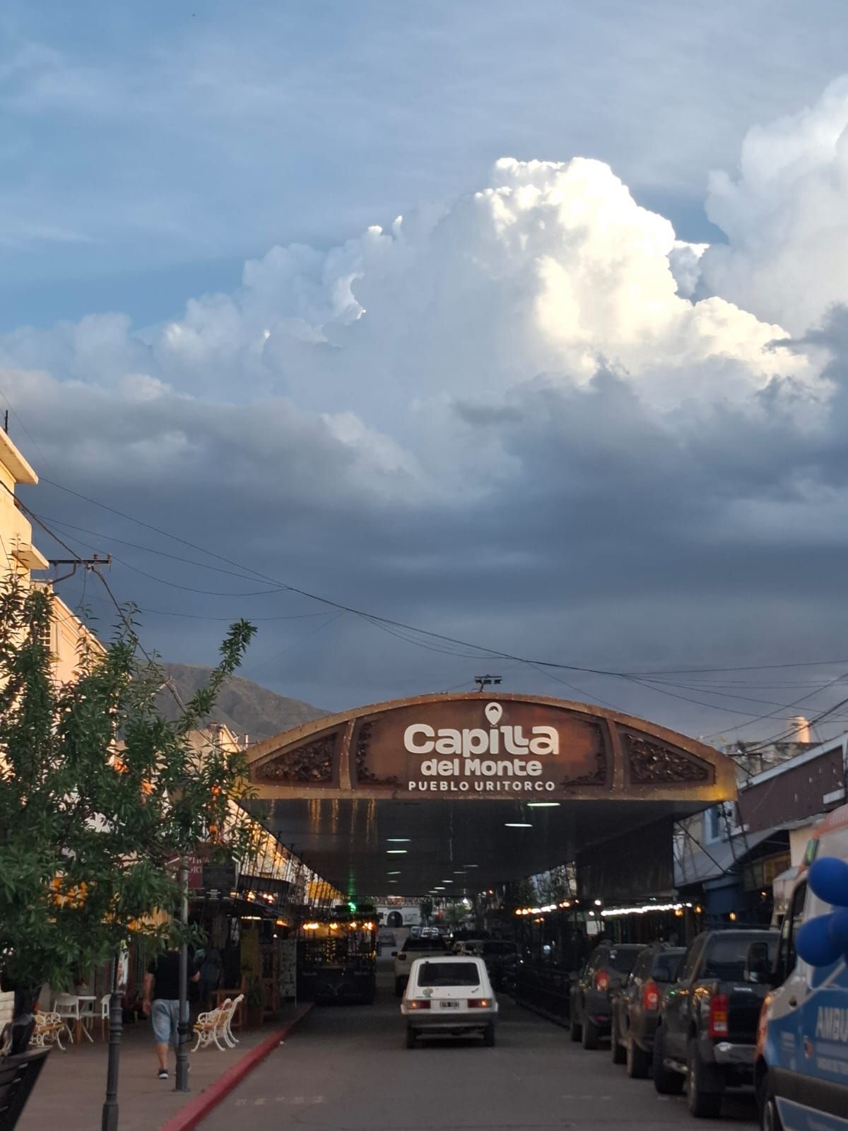 Escena callejera con arco con cartel 