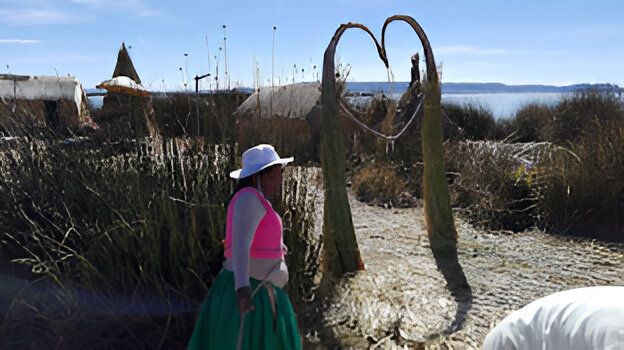 Primer plano de cristales, una vela encendida, manojos de salvia y palo santo sobre una superficie de madera.