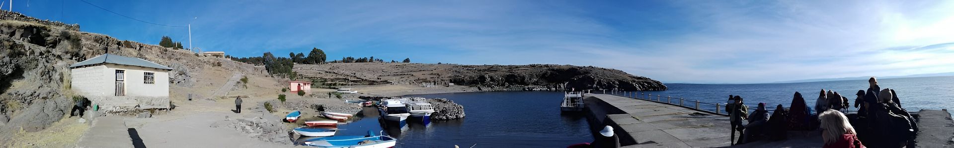 Primer plano de cristales de amatista, esfera de cuarzo rosa y una caja de regalo rosa sobre una superficie de madera.