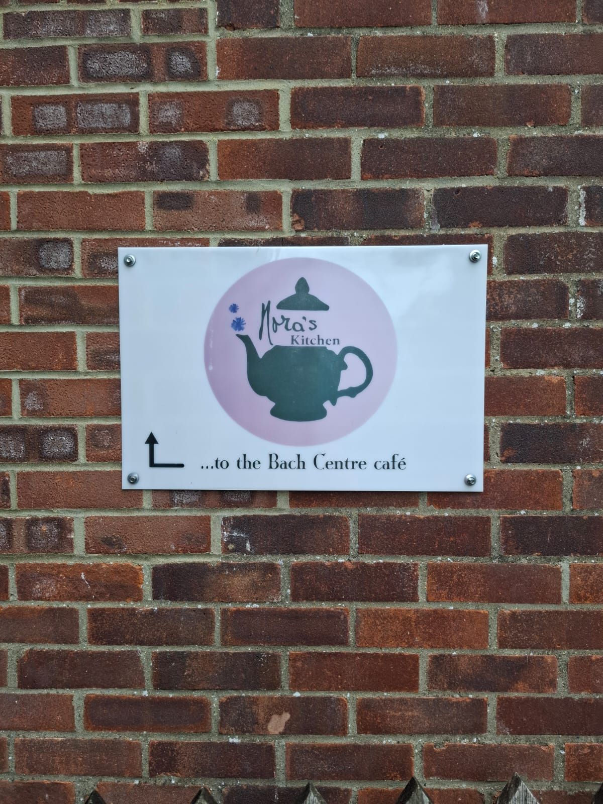 Letrero en pared de ladrillos: logotipo de 