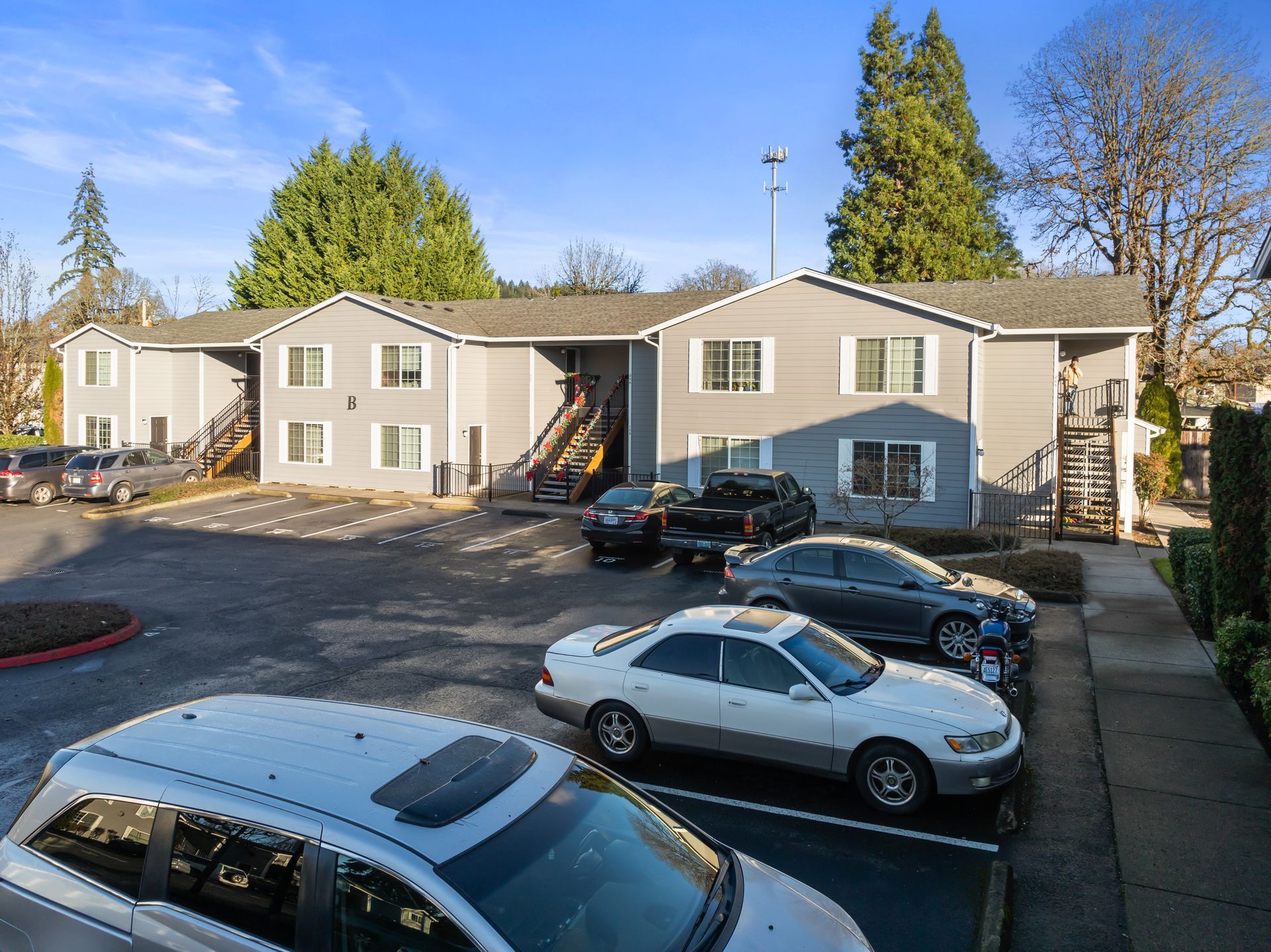 A parking lot with cars parked in front of a building.