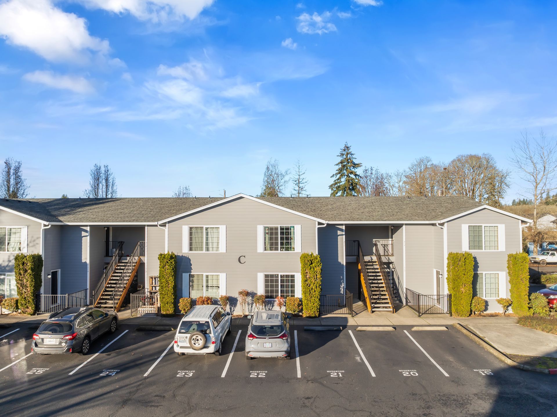 A large apartment building with cars parked in front of it.