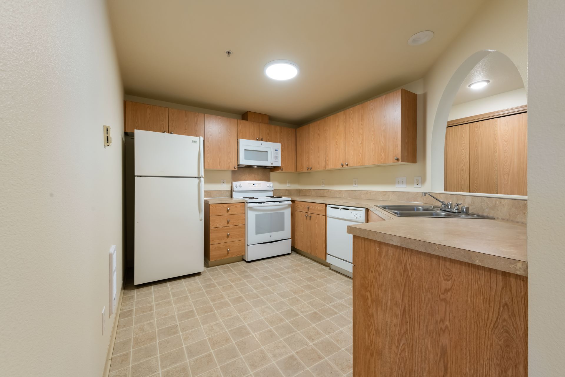 A kitchen with wooden cabinets and a white refrigerator