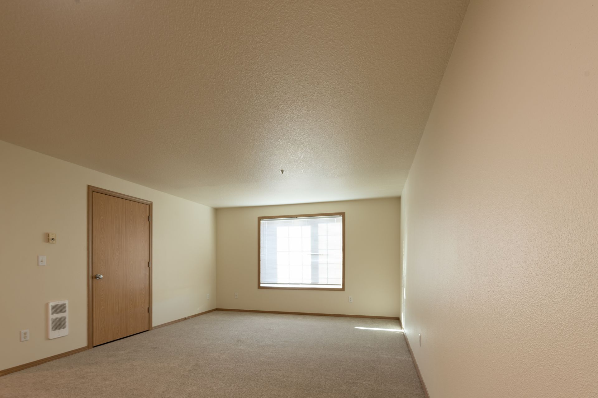 An empty room with a window and a door.