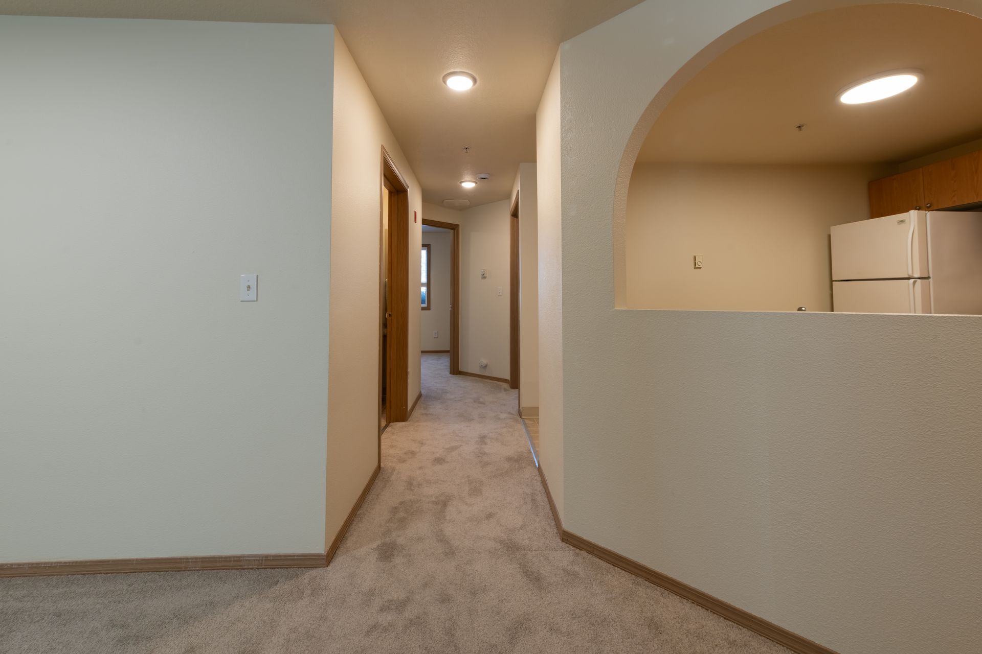 There is a refrigerator in the middle of the hallway.