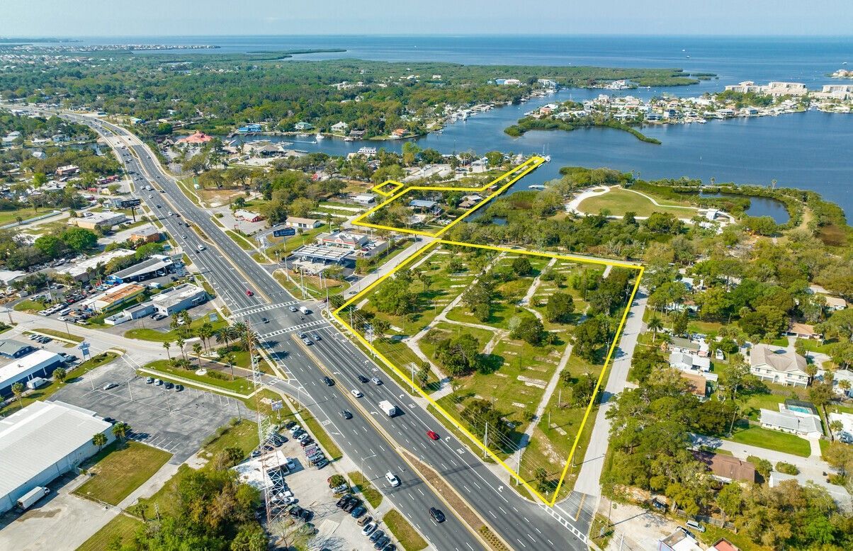 An aerial view of a city with a highway and a lot of trees.