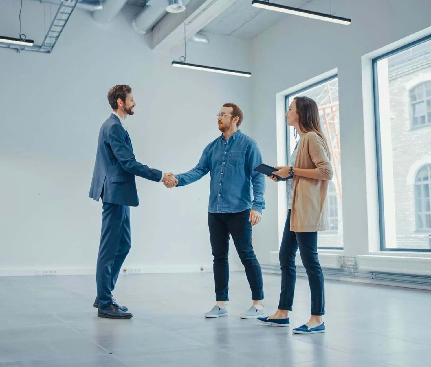 a man and woman shaking hands with a man in a suit