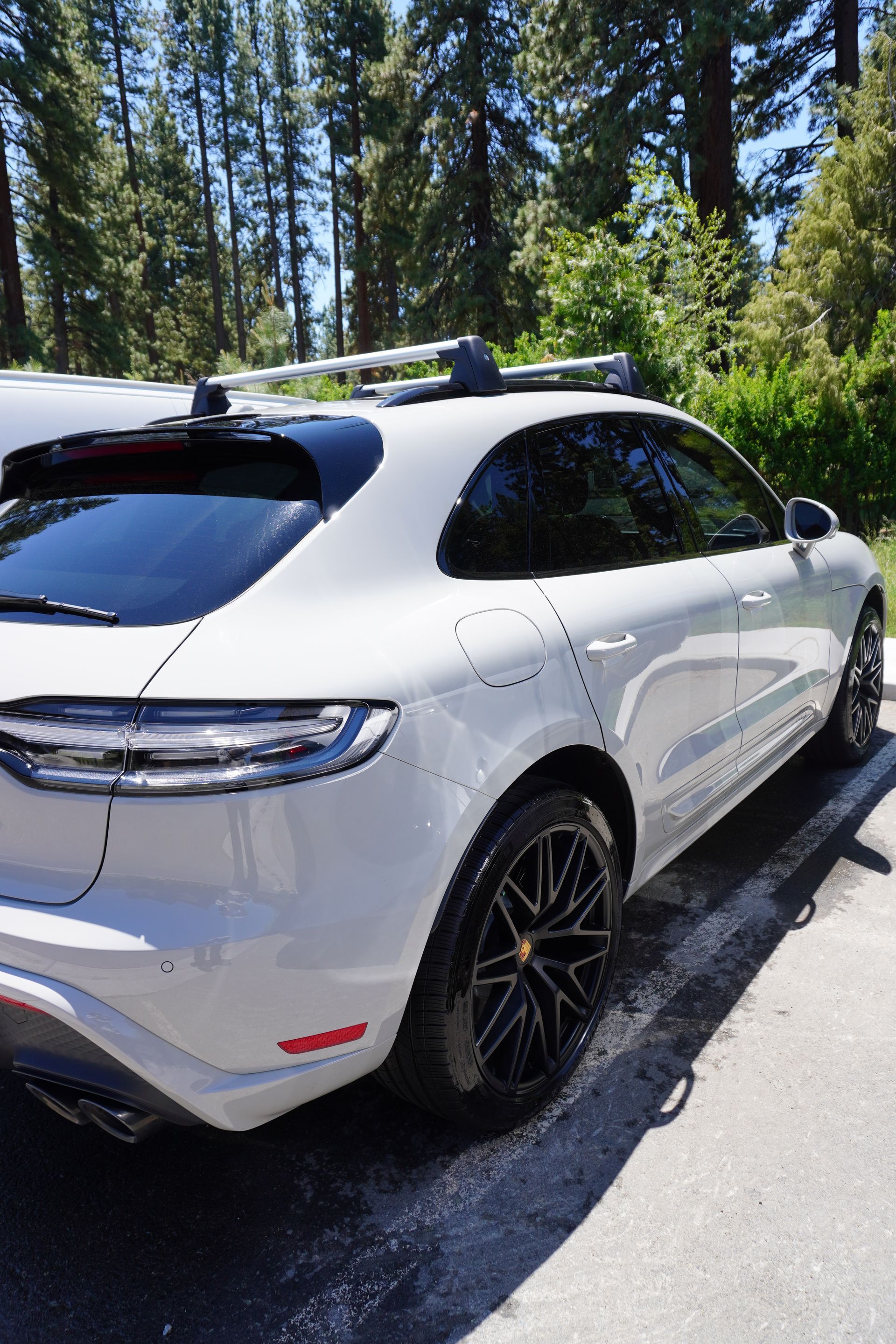 A white porsche macan turbo is parked on the side of the road.