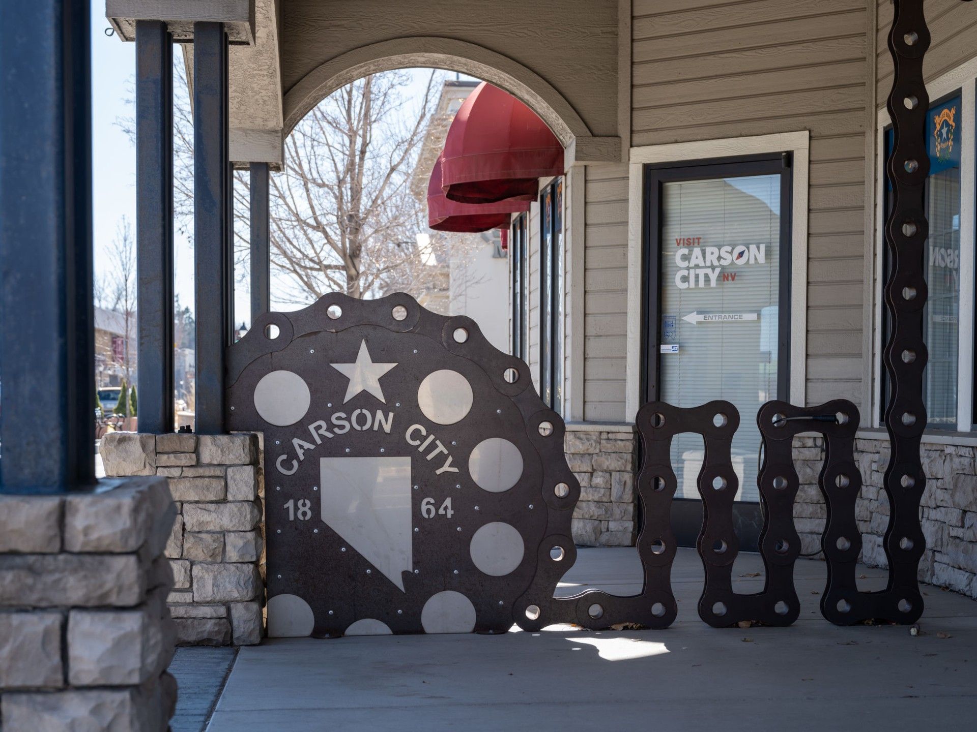 A carson city sign is on the sidewalk in front of a building