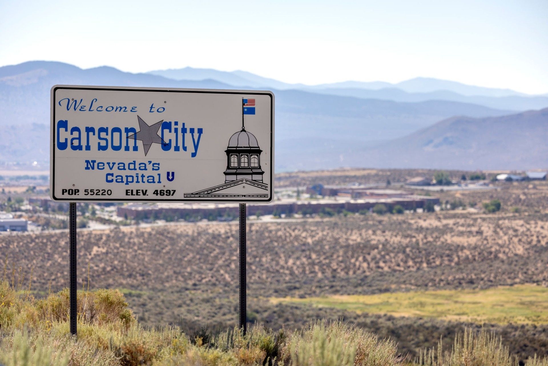 A welcome to carson city sign in the desert