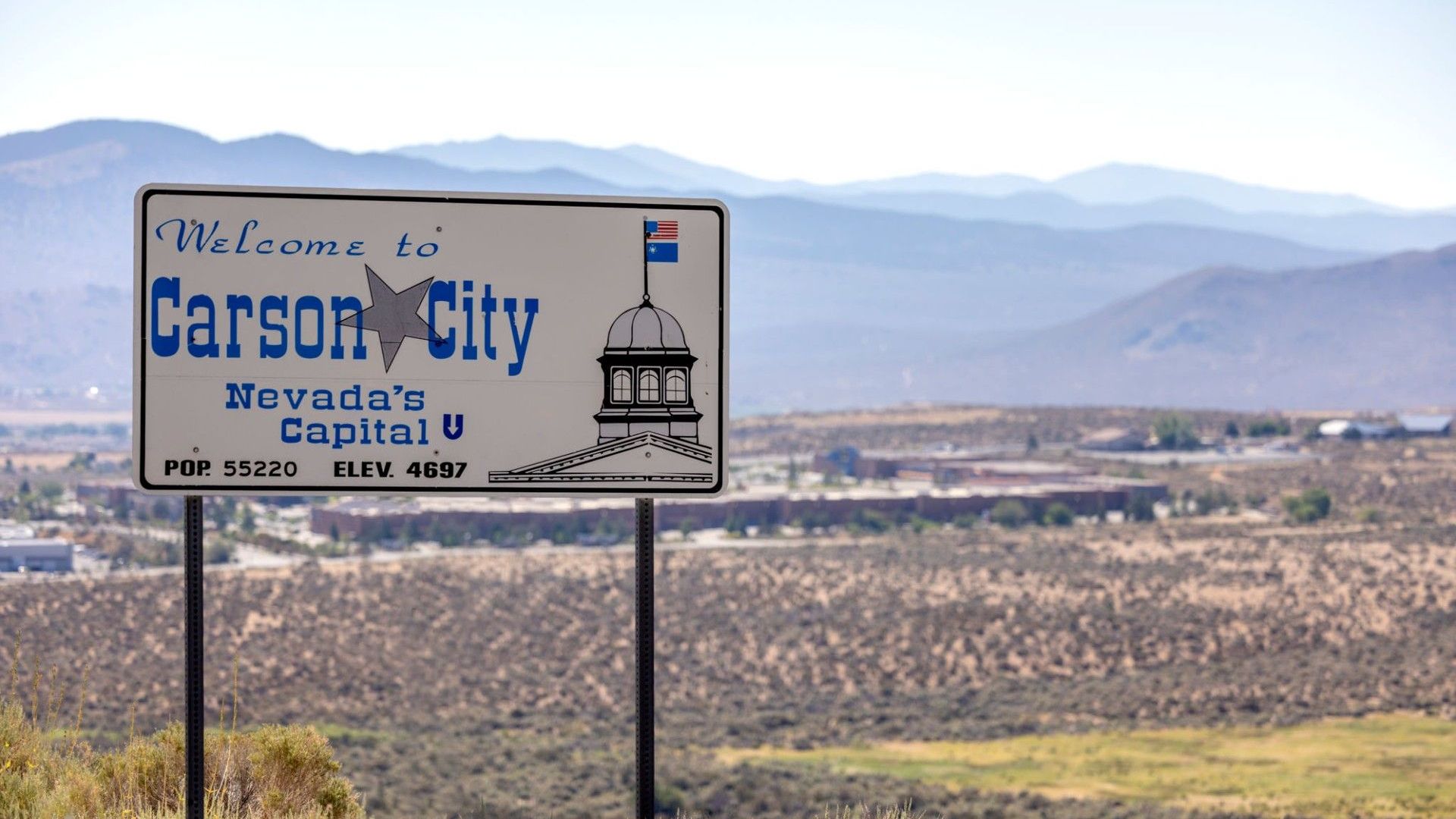 A welcome to carson city sign in the desert
