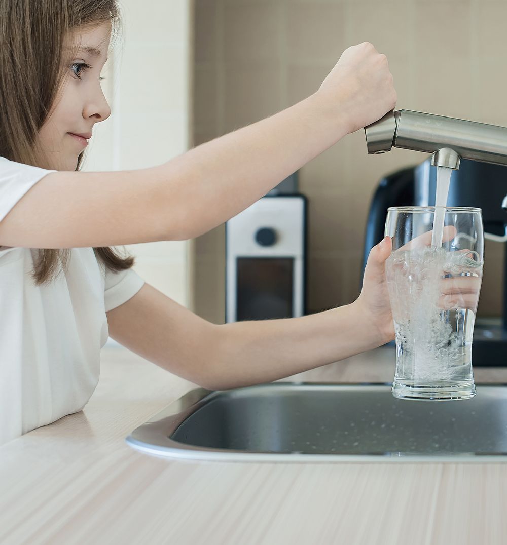 girl filling in a glass of water