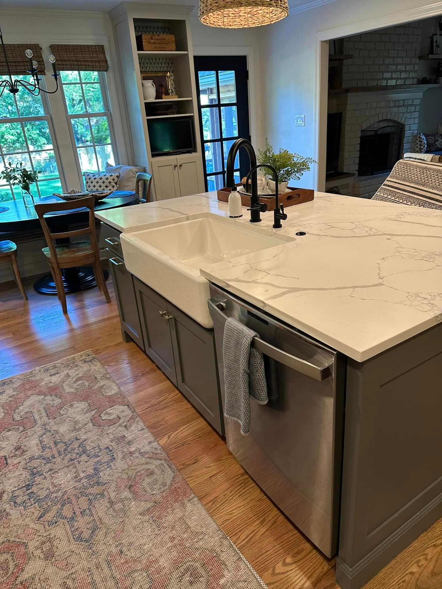 A kitchen with a large island , sink , and dishwasher.