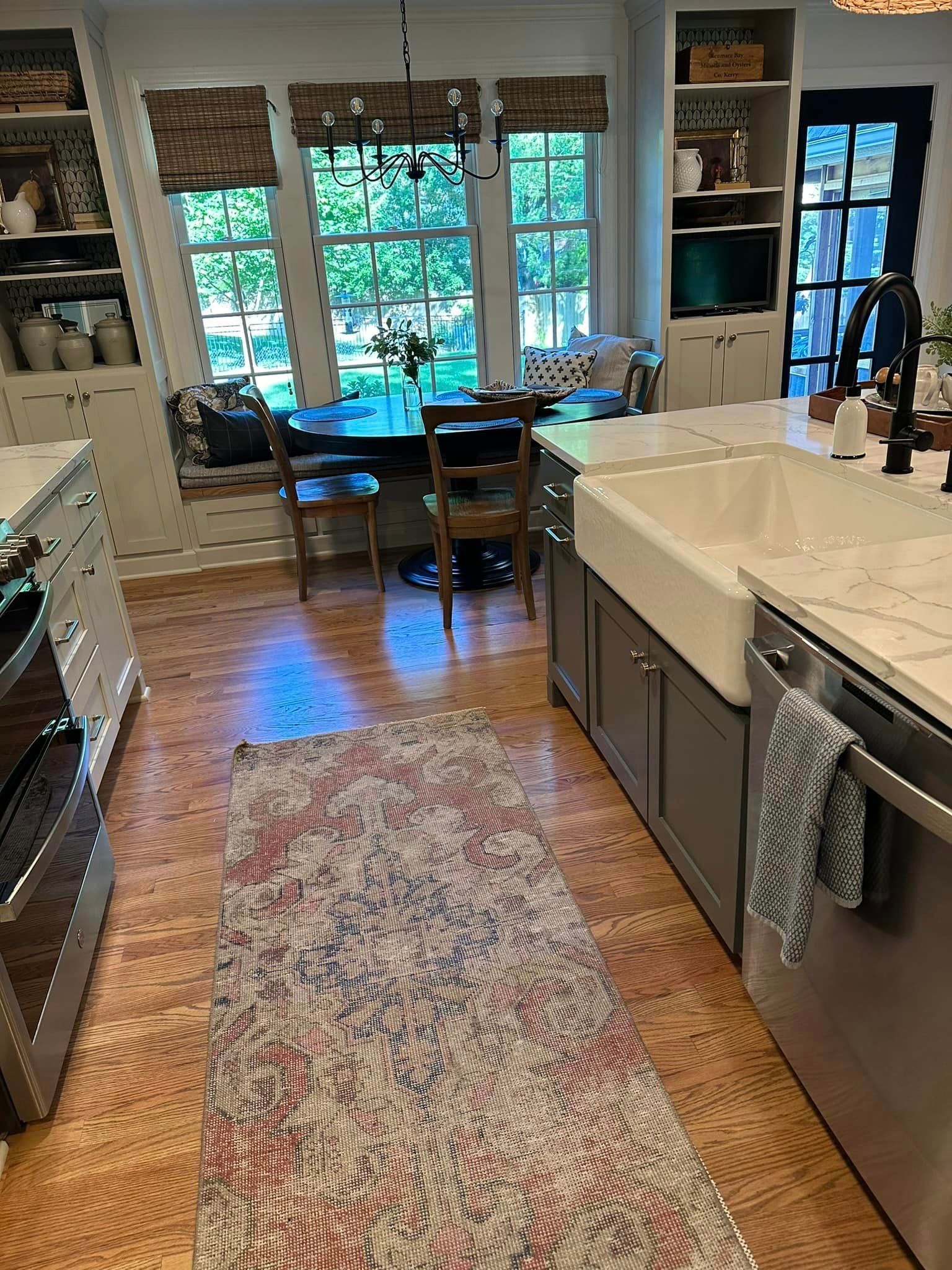 A kitchen with a rug on the floor and a sink.