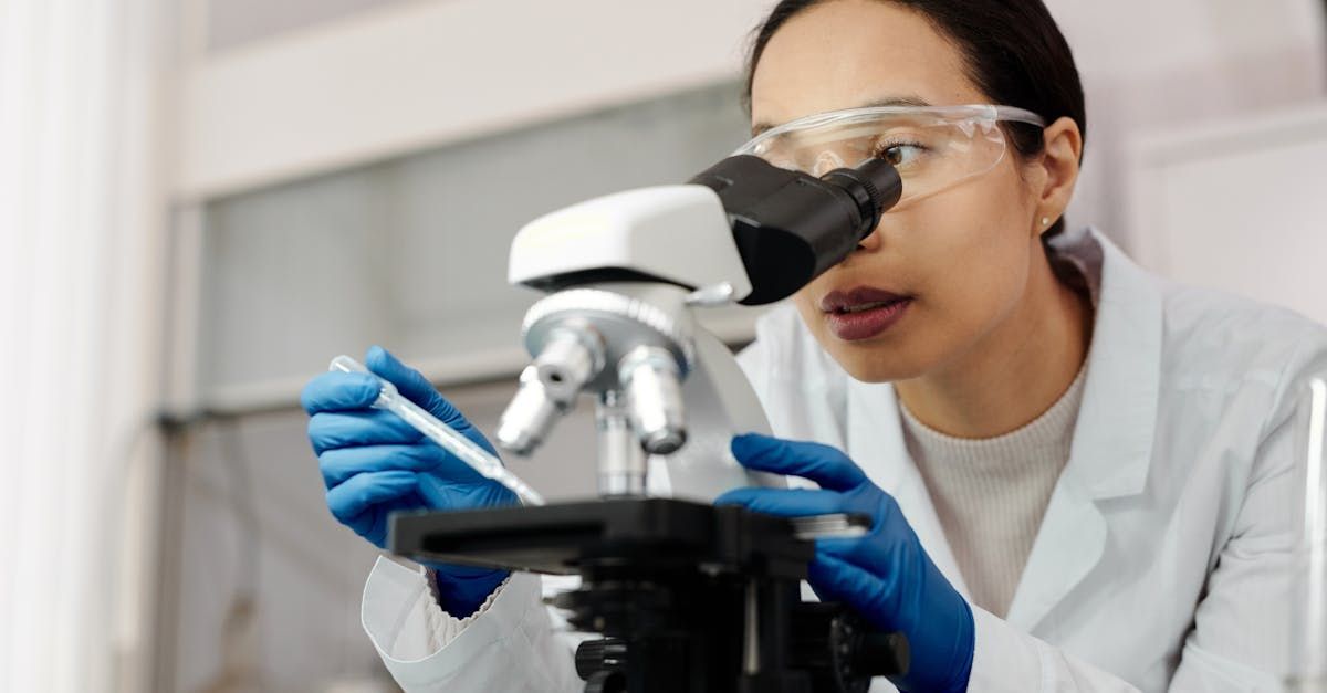 A female scientist is looking through a microscope in a laboratory.