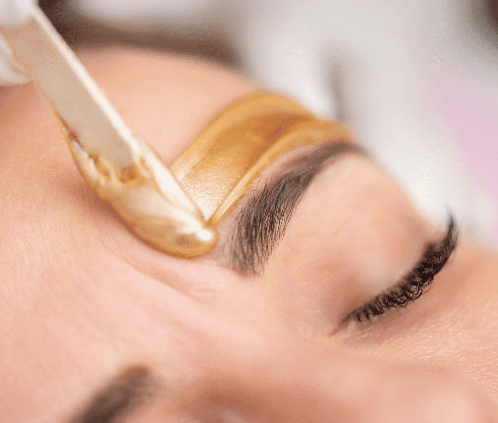 A woman is getting her eyebrows waxed in a beauty salon.