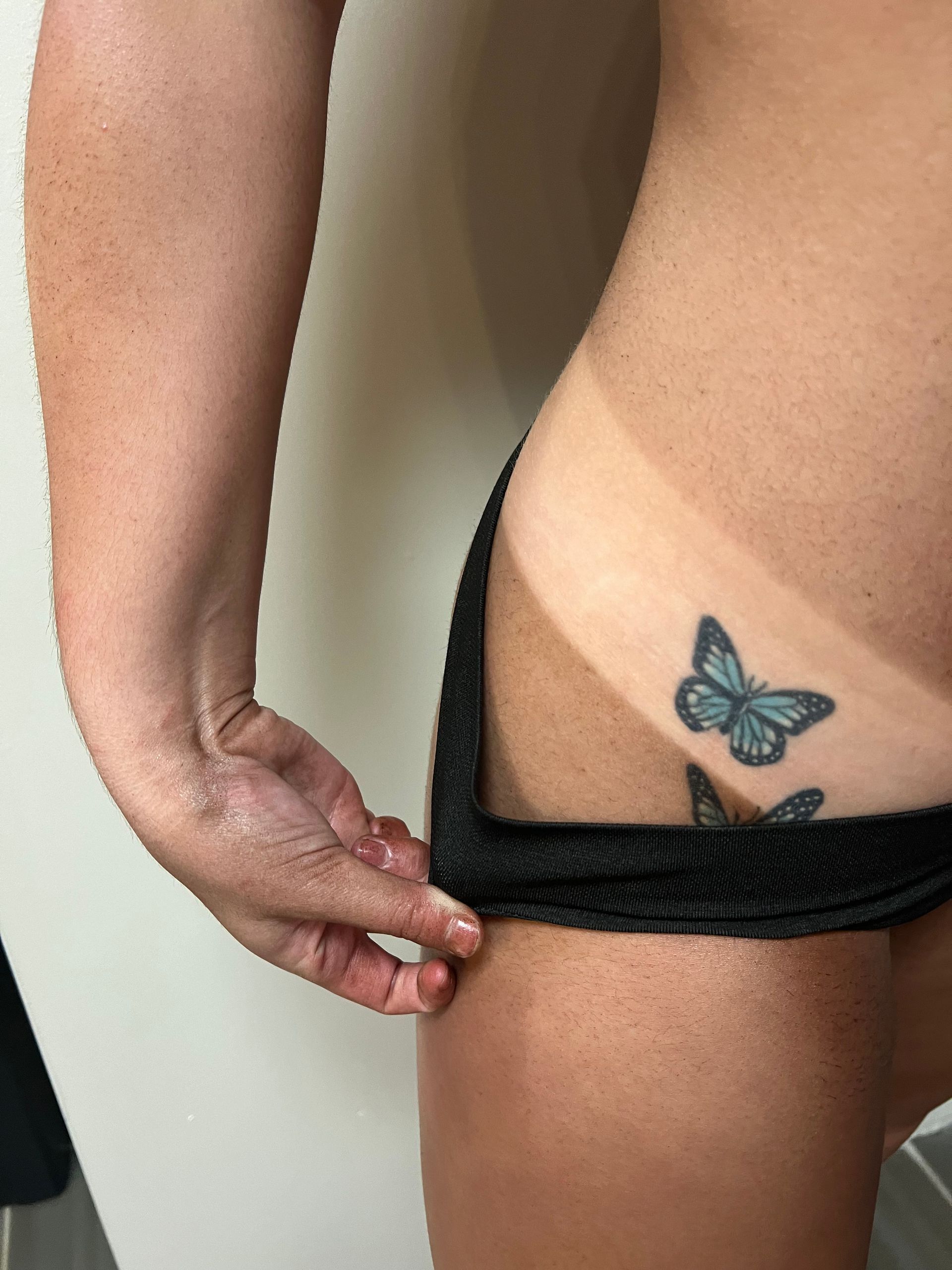 A woman with a butterfly tattoo on her hip