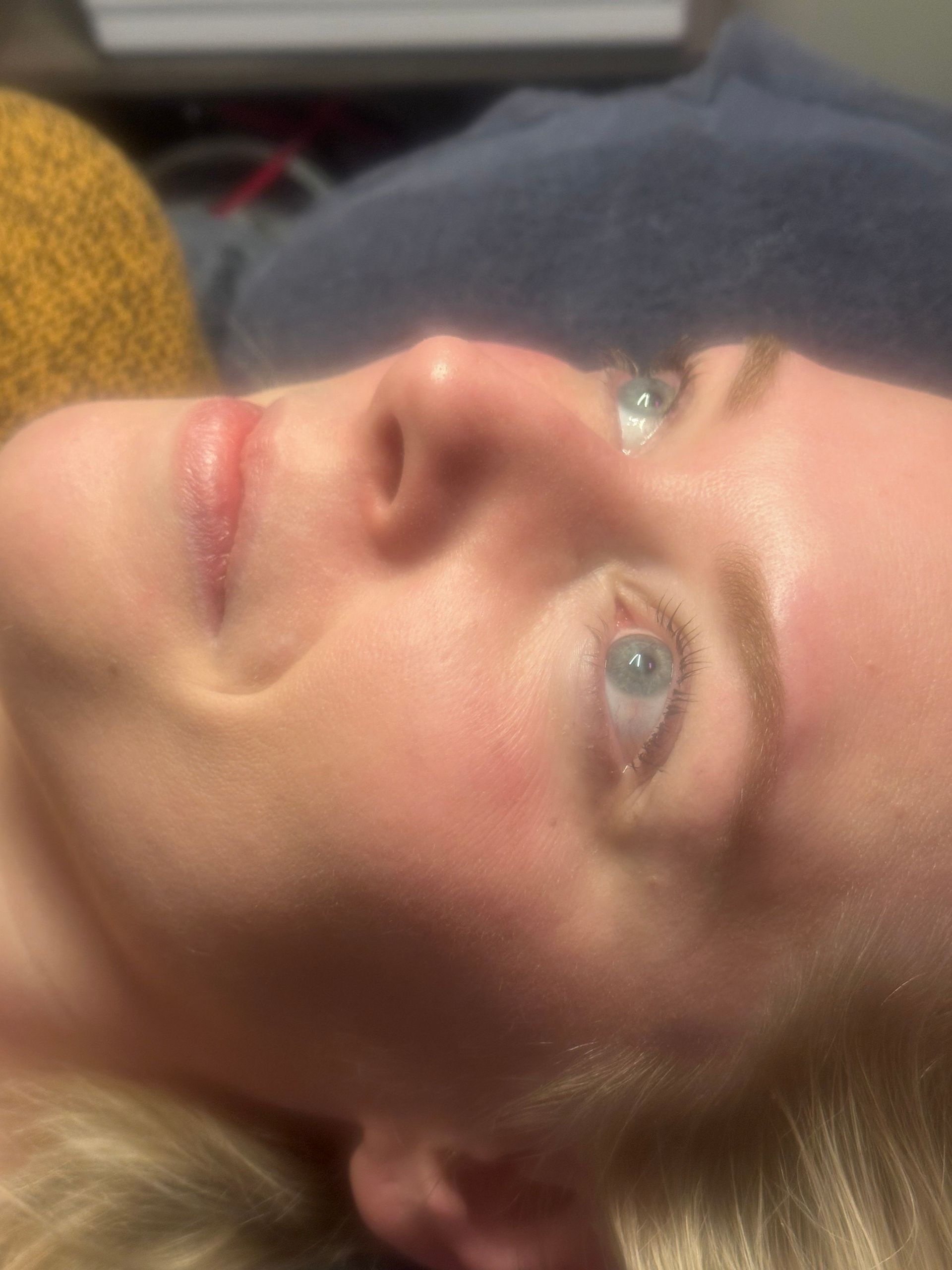 A close up of a woman 's face with blue eyes.