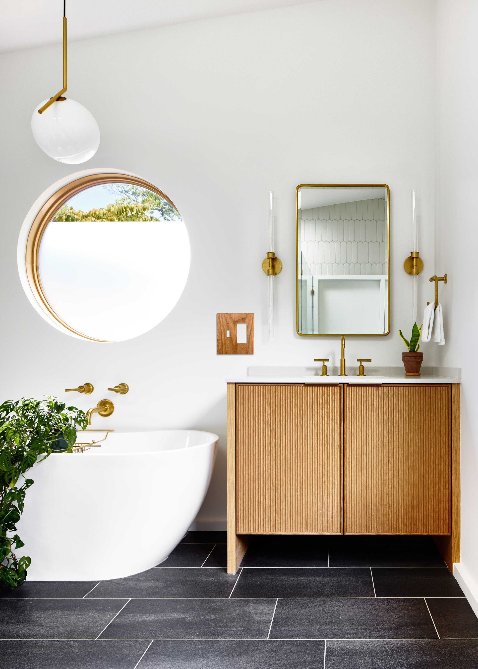 A bathroom with a tub , sink and mirror displaying 2 gang switch plate.
