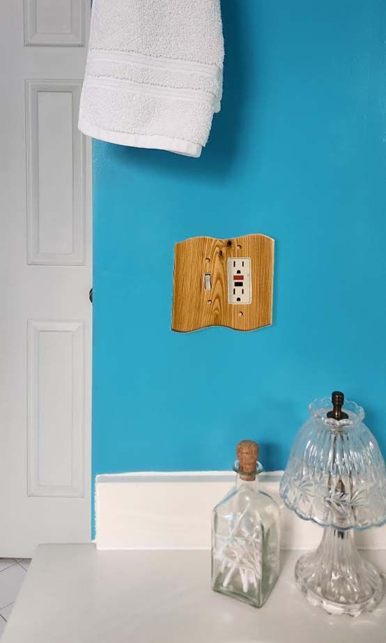 A blue wall with a combination wood switch plate cover.