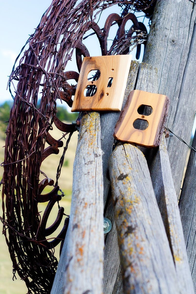 Two wooden electrical outlets are sitting on a wooden post
