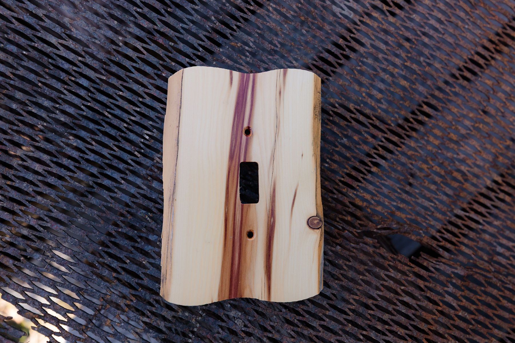 A wooden light switch is sitting on a metal table