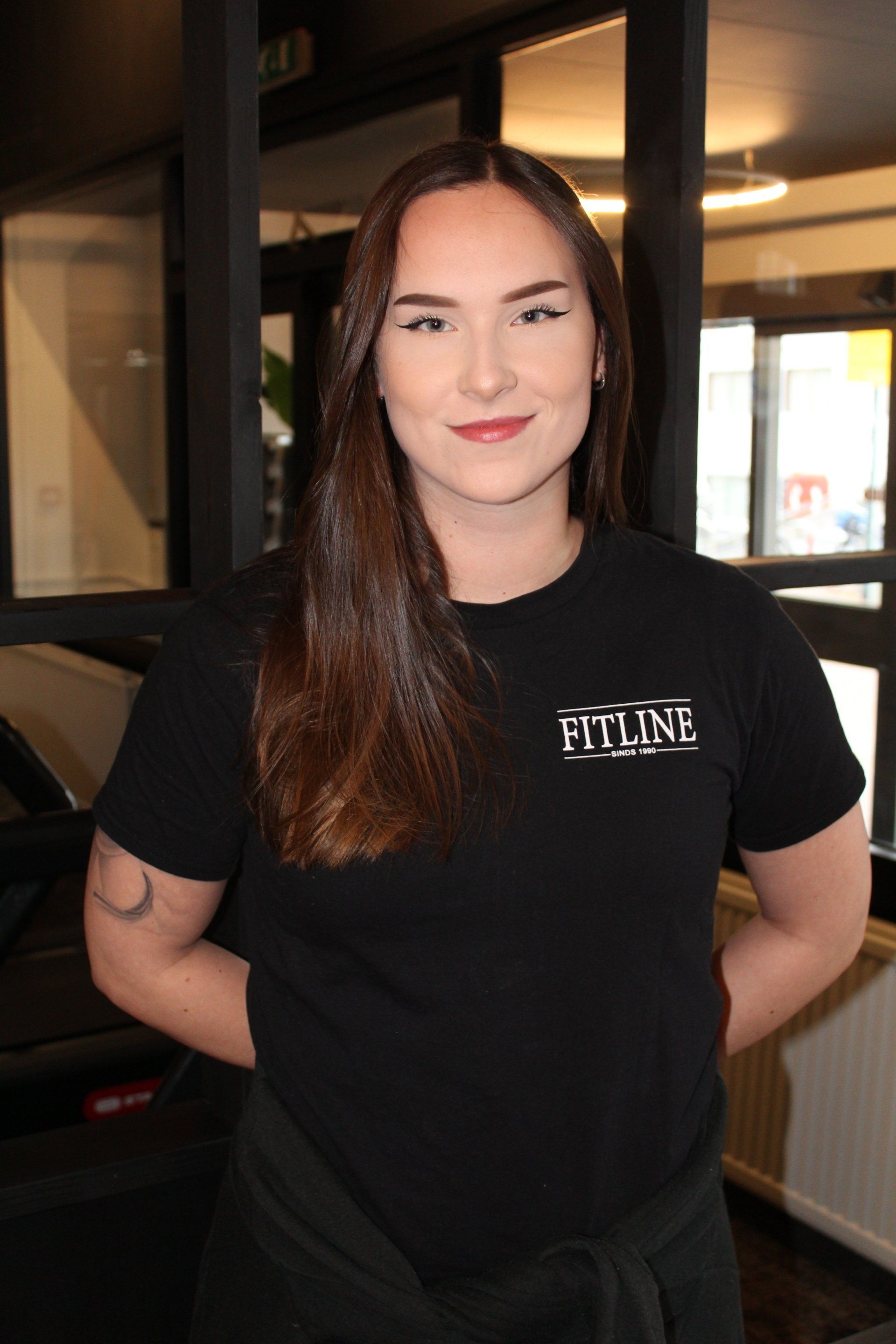 Een vrouw die een zwart t-shirt draagt ​​met het woord flyline erop.