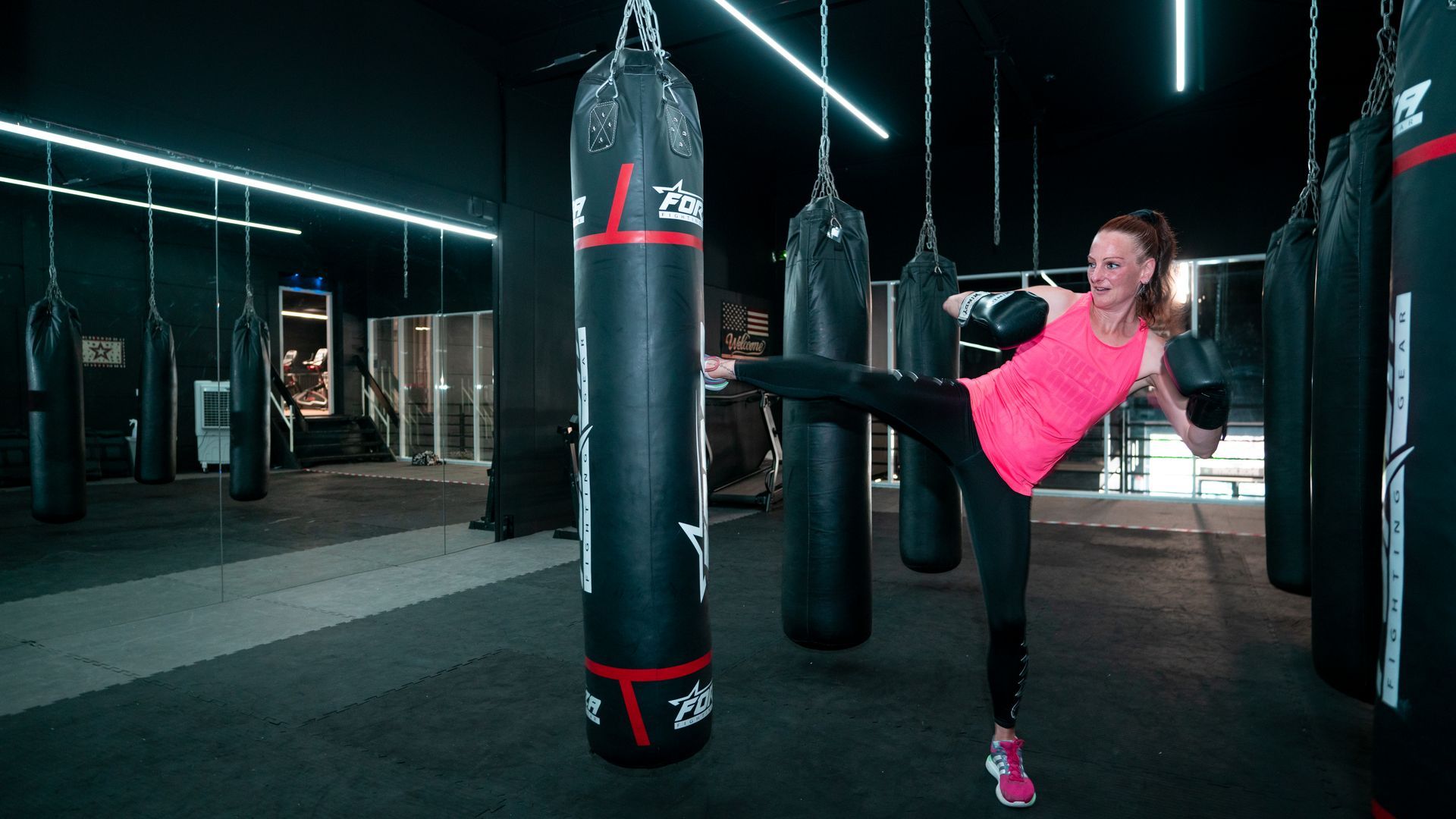 Een persoon tilt een halter op in een sportschool.