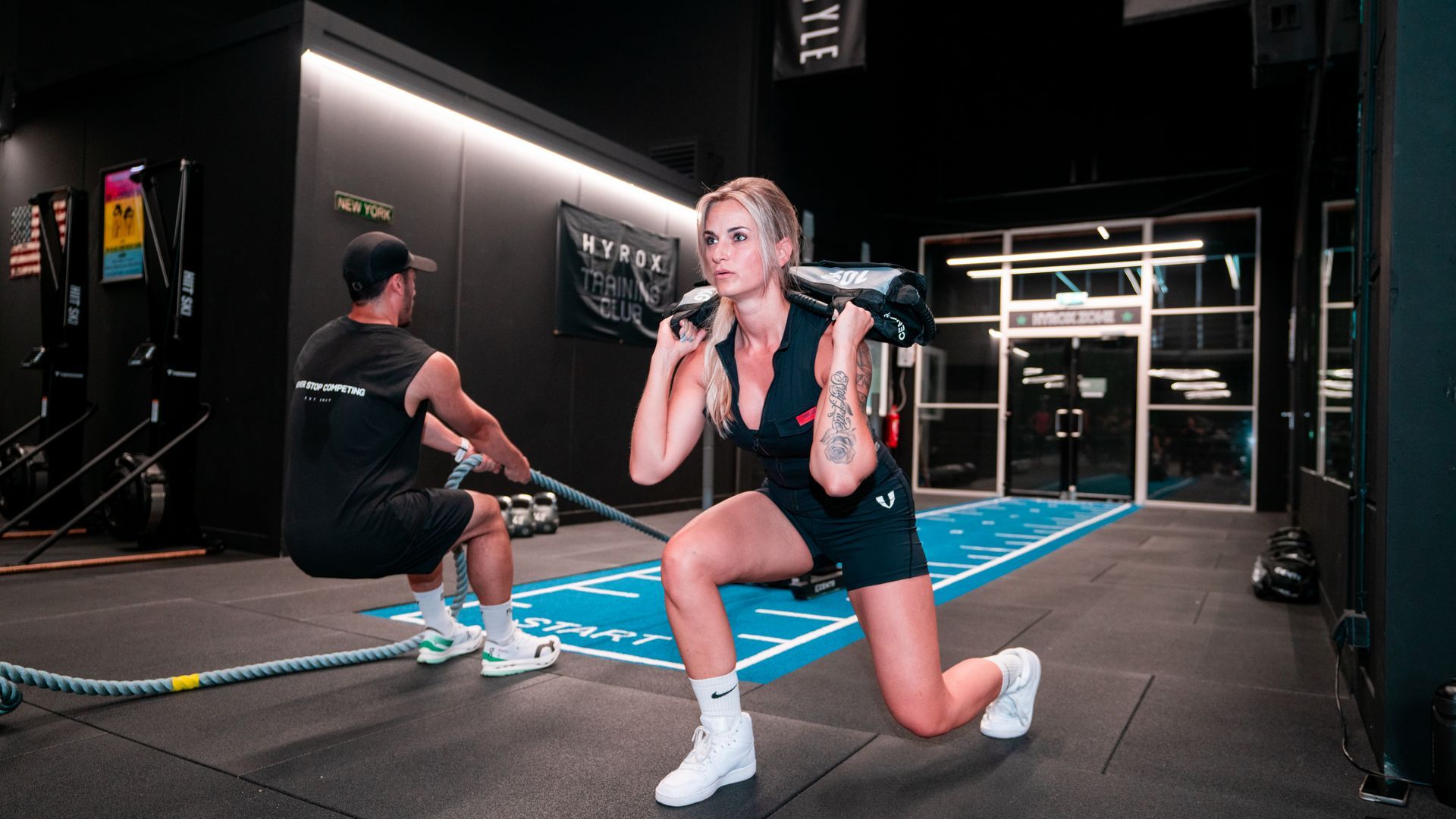 Een man en een vrouw doen squats in een sportschool.
