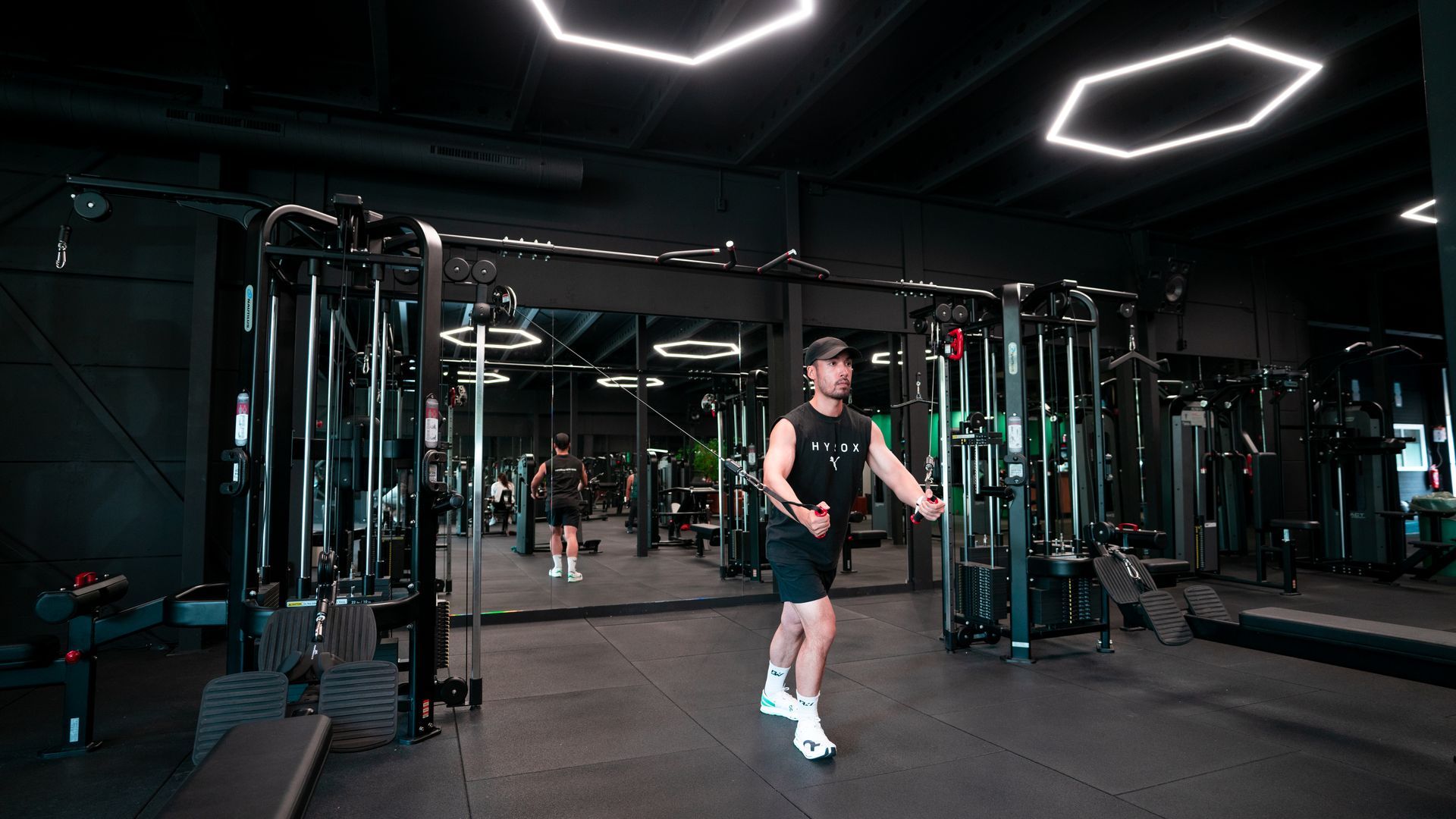 Een man helpt een vrouw met het tillen van een halter in de sportschool.
