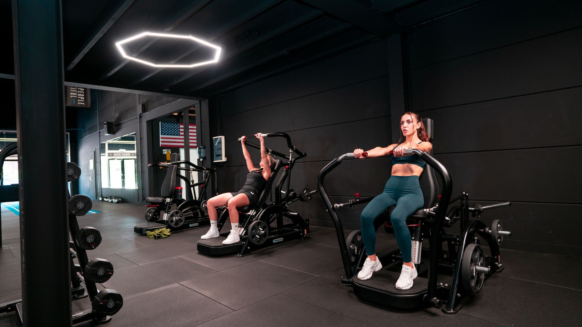 Een man helpt een vrouw met het tillen van een halter in de sportschool.