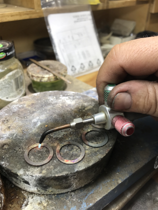 A person is working on a piece of metal with a torch.
