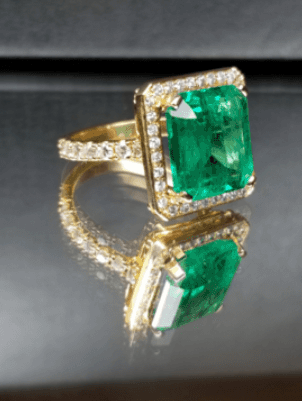 A gold ring with an emerald and diamonds