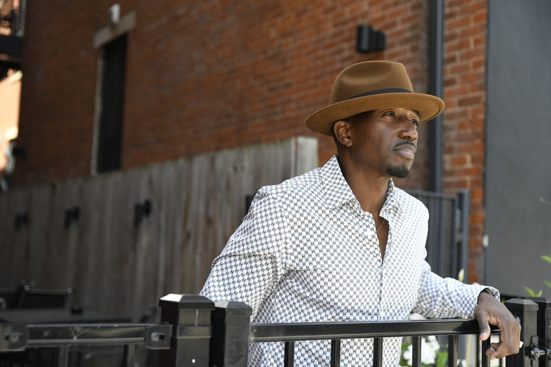 Corey Tucker wearing a hat is leaning on a railing.