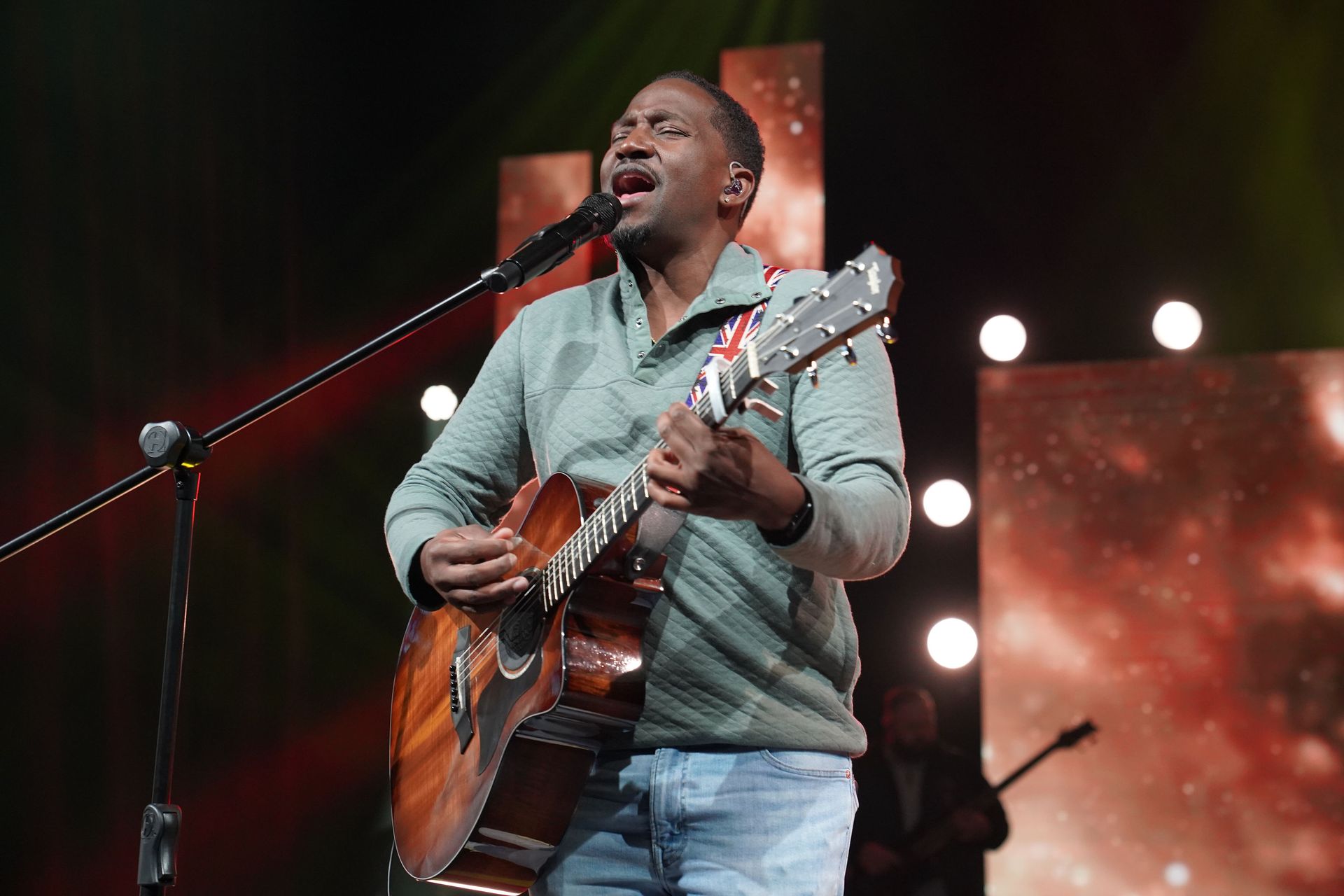 Corey Tucker with guitar signing in microphone
