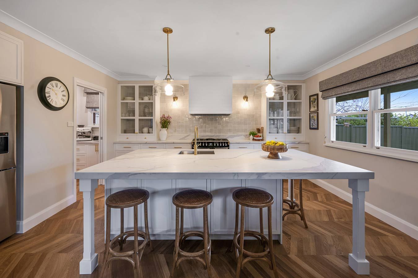 A Kitchen With a Large Island and Stools and a Clock on the Wall — Simmonds Kitchens & Detailed Joinery in Quirindi, NSW