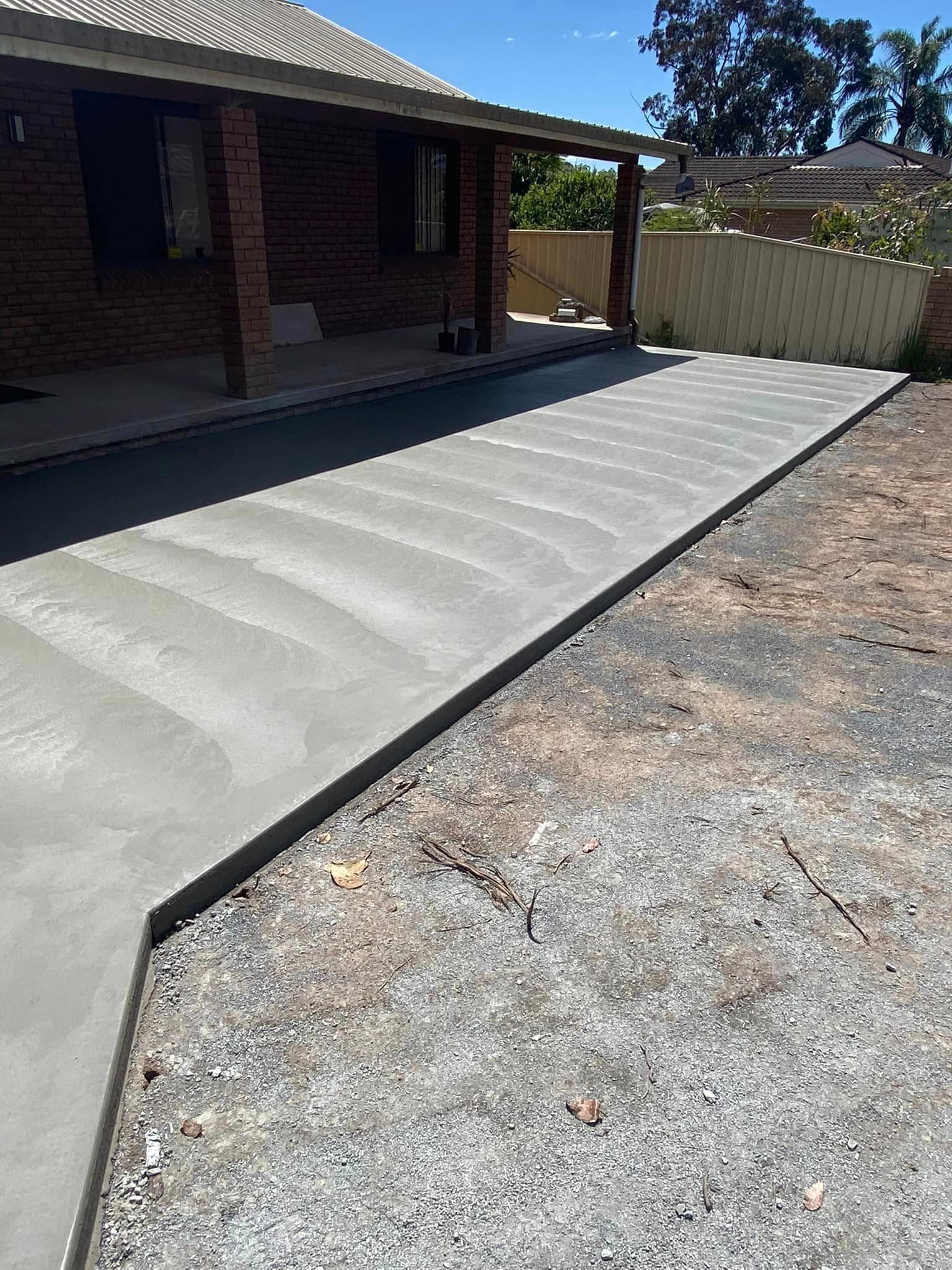 Freshly Poured Concrete Pathway Alongside a Brick — Williams Concreting In Taree, NSW