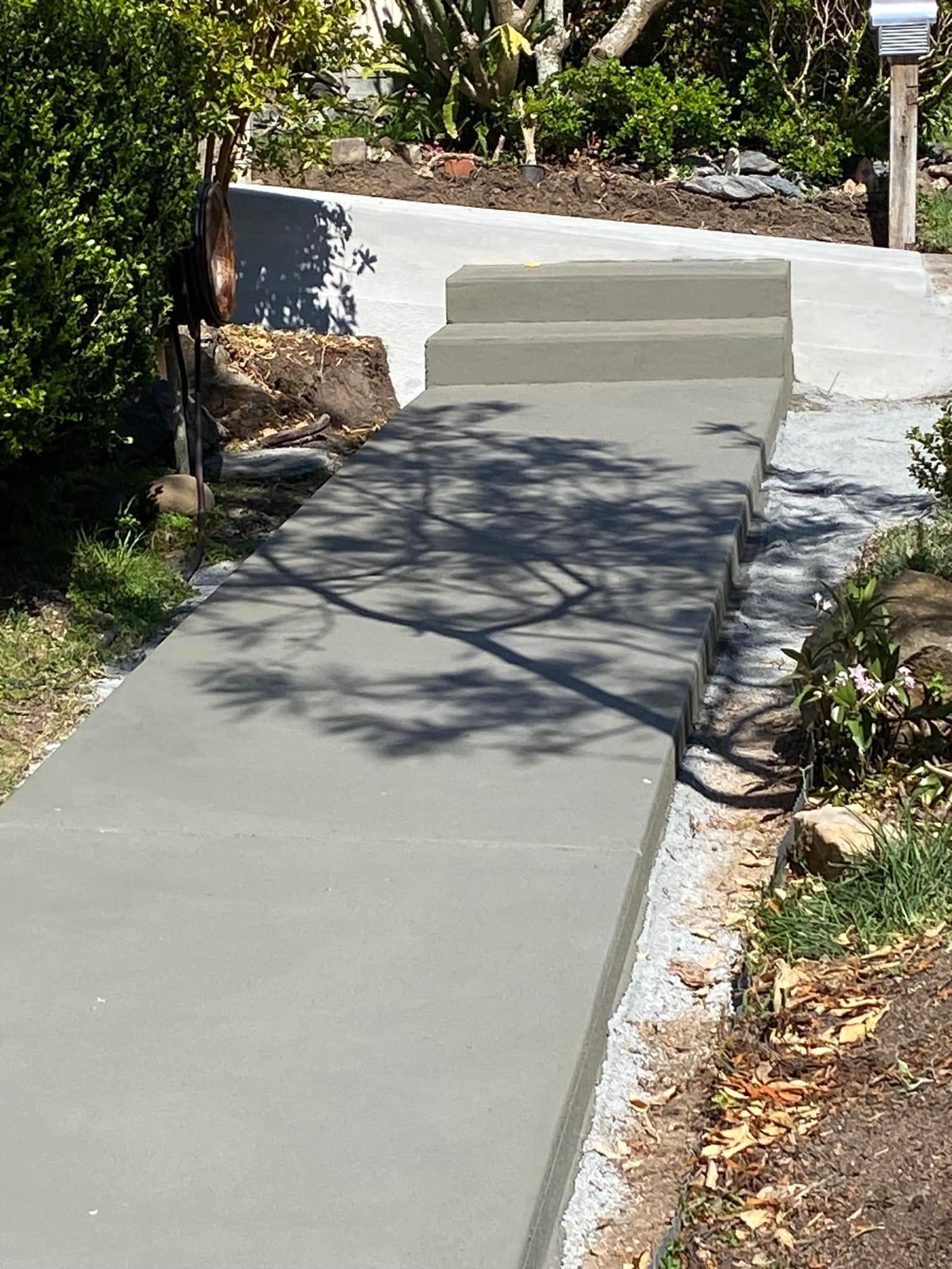 Concrete Walkway With Steps Leading to a Garden; Sunlight Creates Tree Shadow — Williams Concreting In Taree, NSW