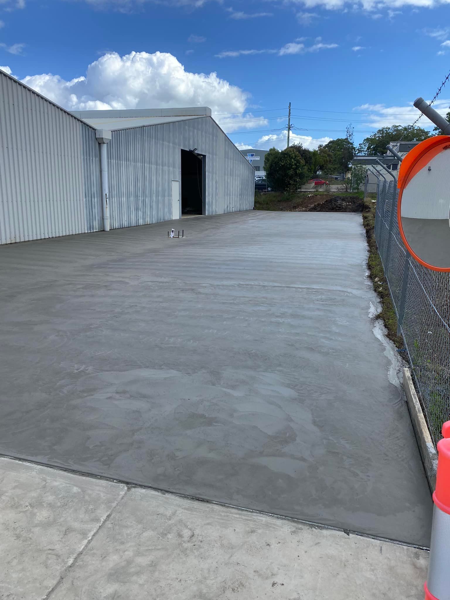 Newly poured concrete surface next to a shed — Williams Concreting In Forster, NSW