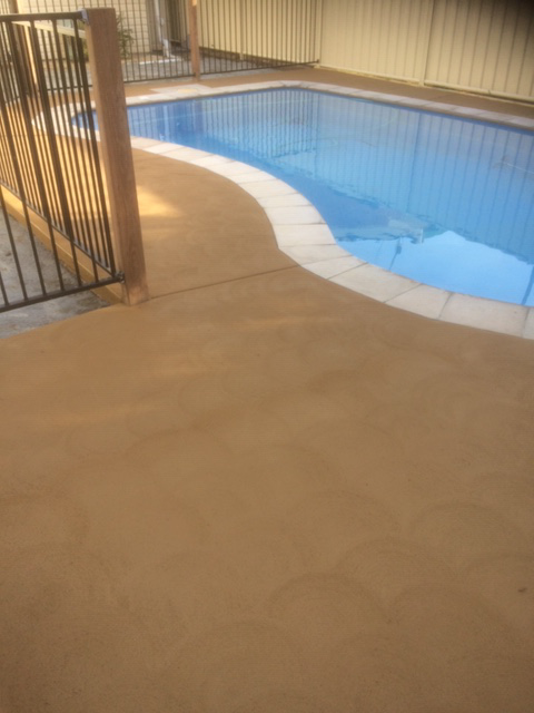 Pool With Tan Concrete Surround and Blue Water, Fenced in Area — Williams Concreting In Old Bar, NSW