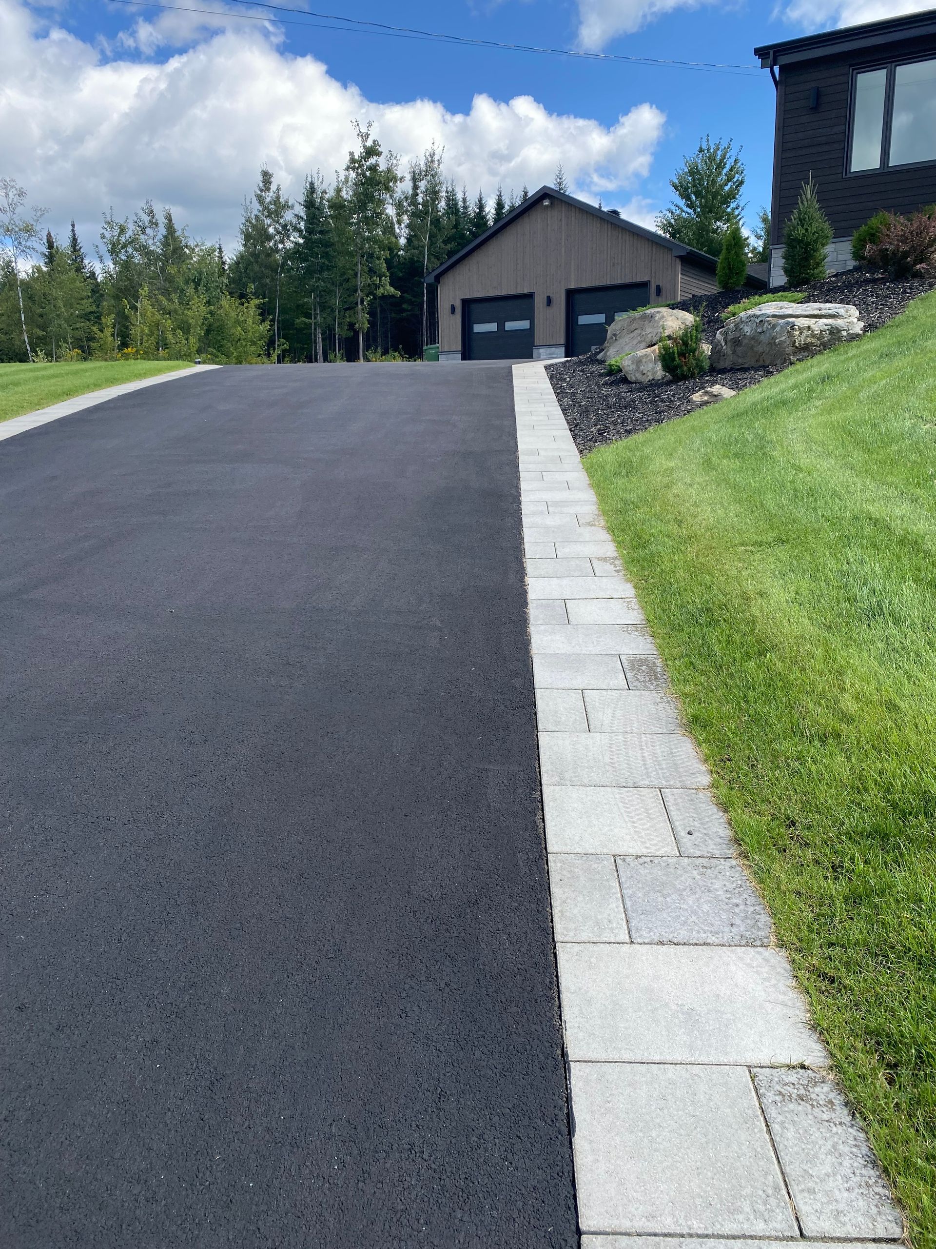 Une allée menant à une maison avec deux portes de garage