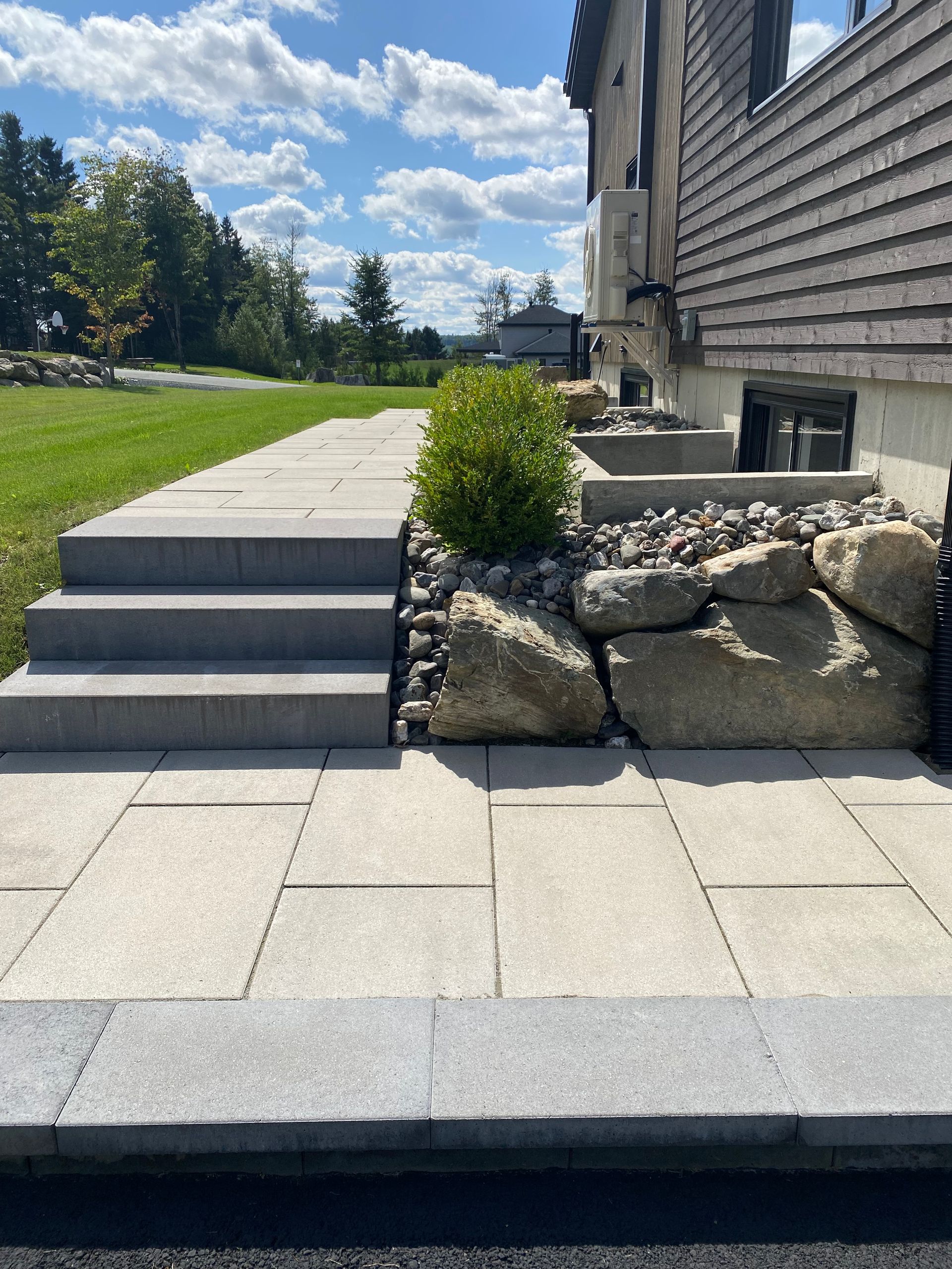 Une allée en pierre avec des escaliers menant à une maison.