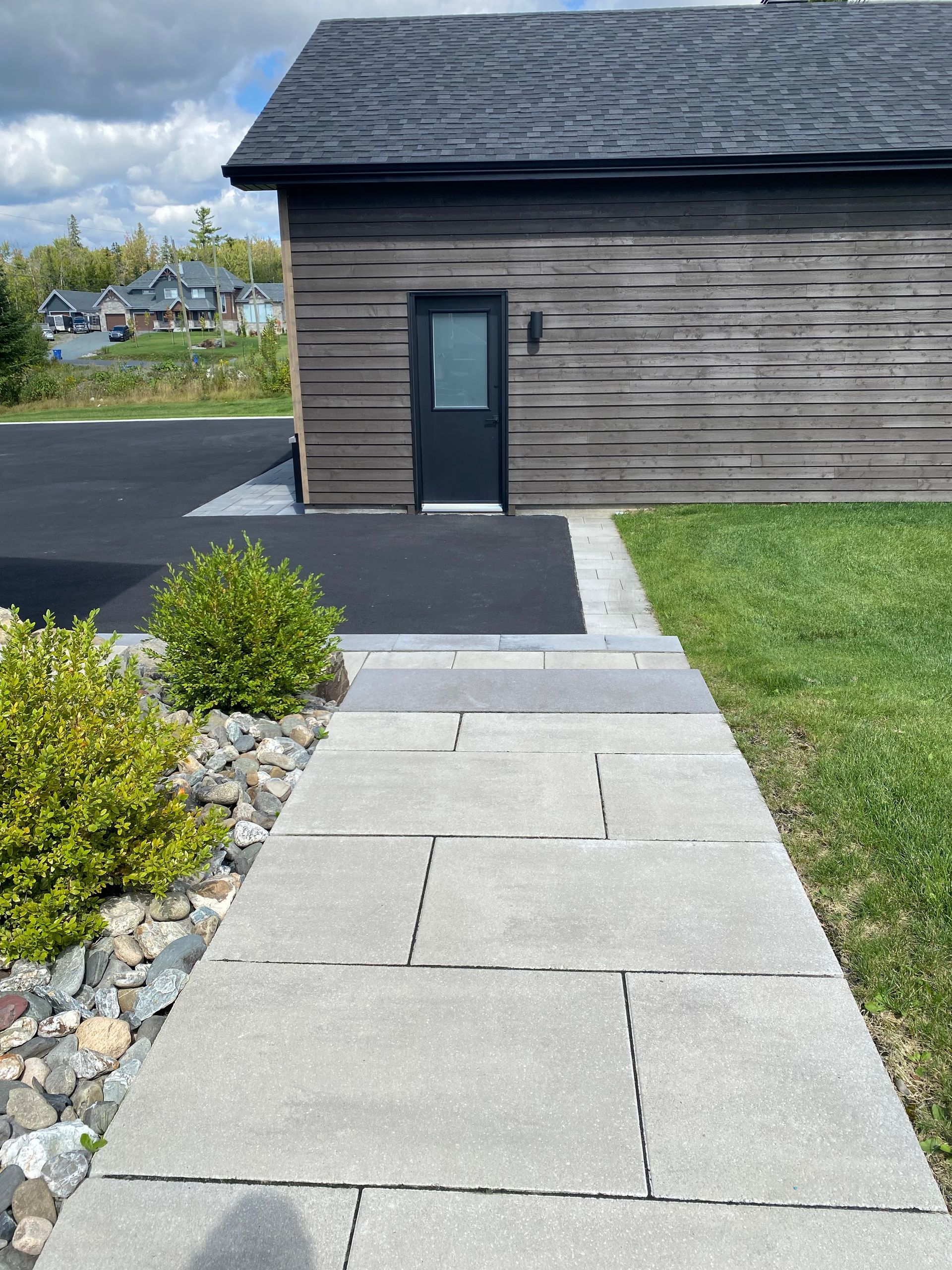 Une passerelle menant à une maison avec une porte noire