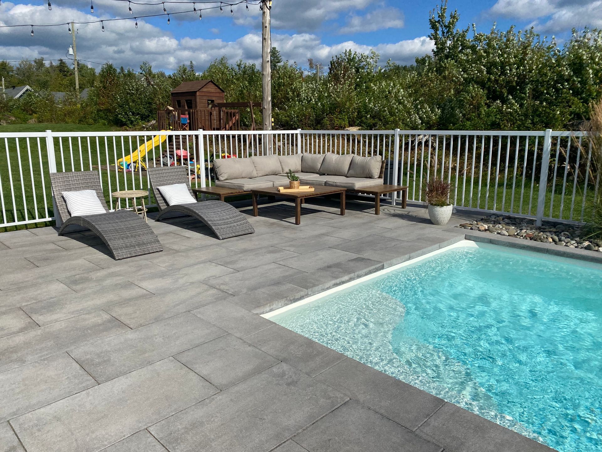 Un patio avec une piscine et un canapé et des chaises