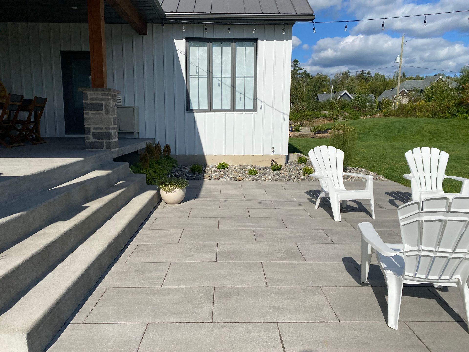 Un patio avec des chaises et des escaliers devant une maison