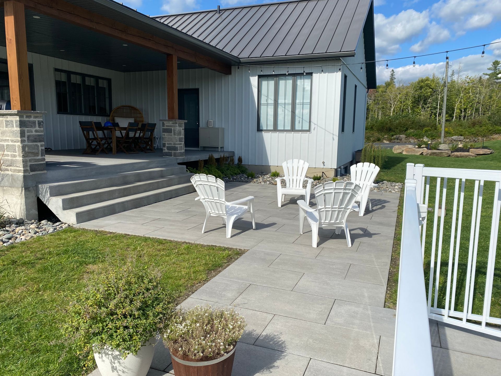 Un patio avec des chaises et une table devant une maison.