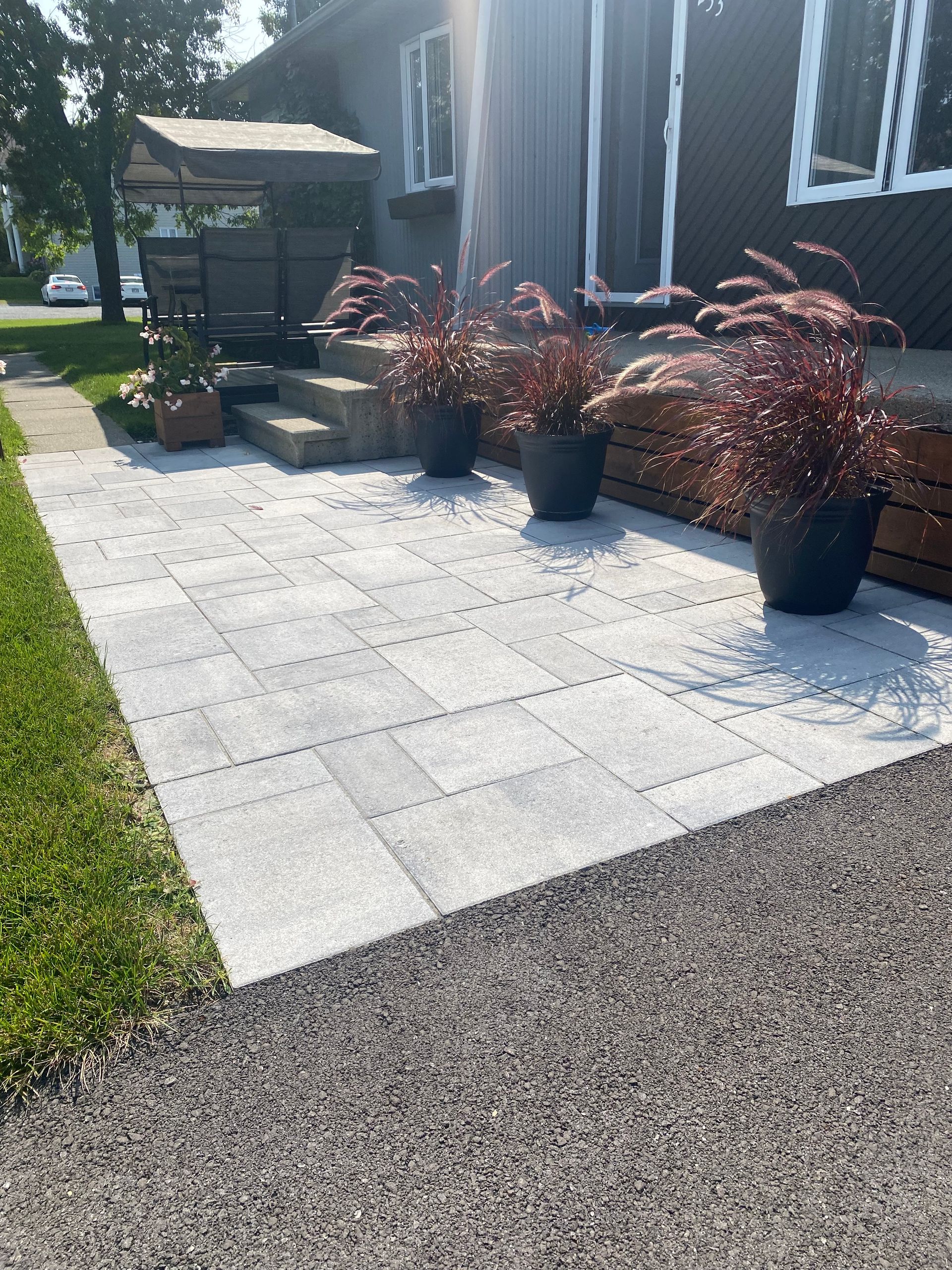 Un patio avec des plantes en pot devant une maison