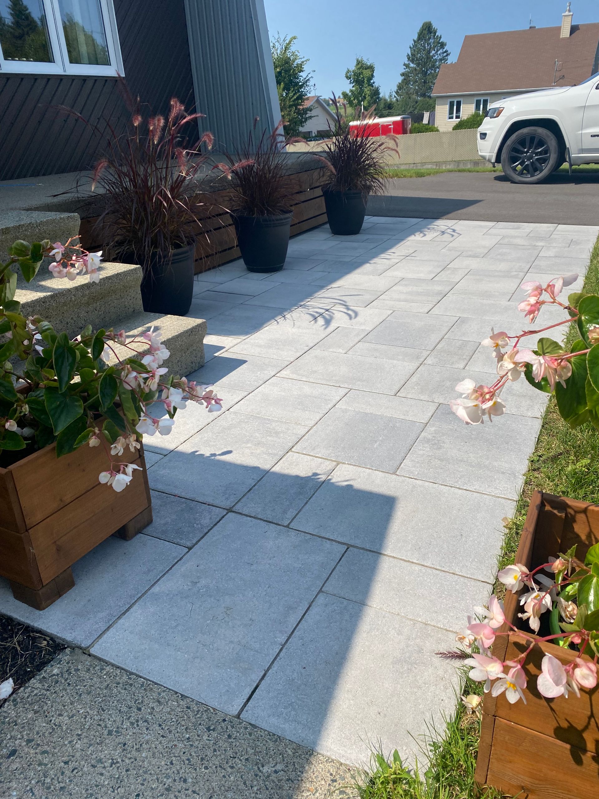 Un camion blanc est garé sur le bord de la route devant une maison.